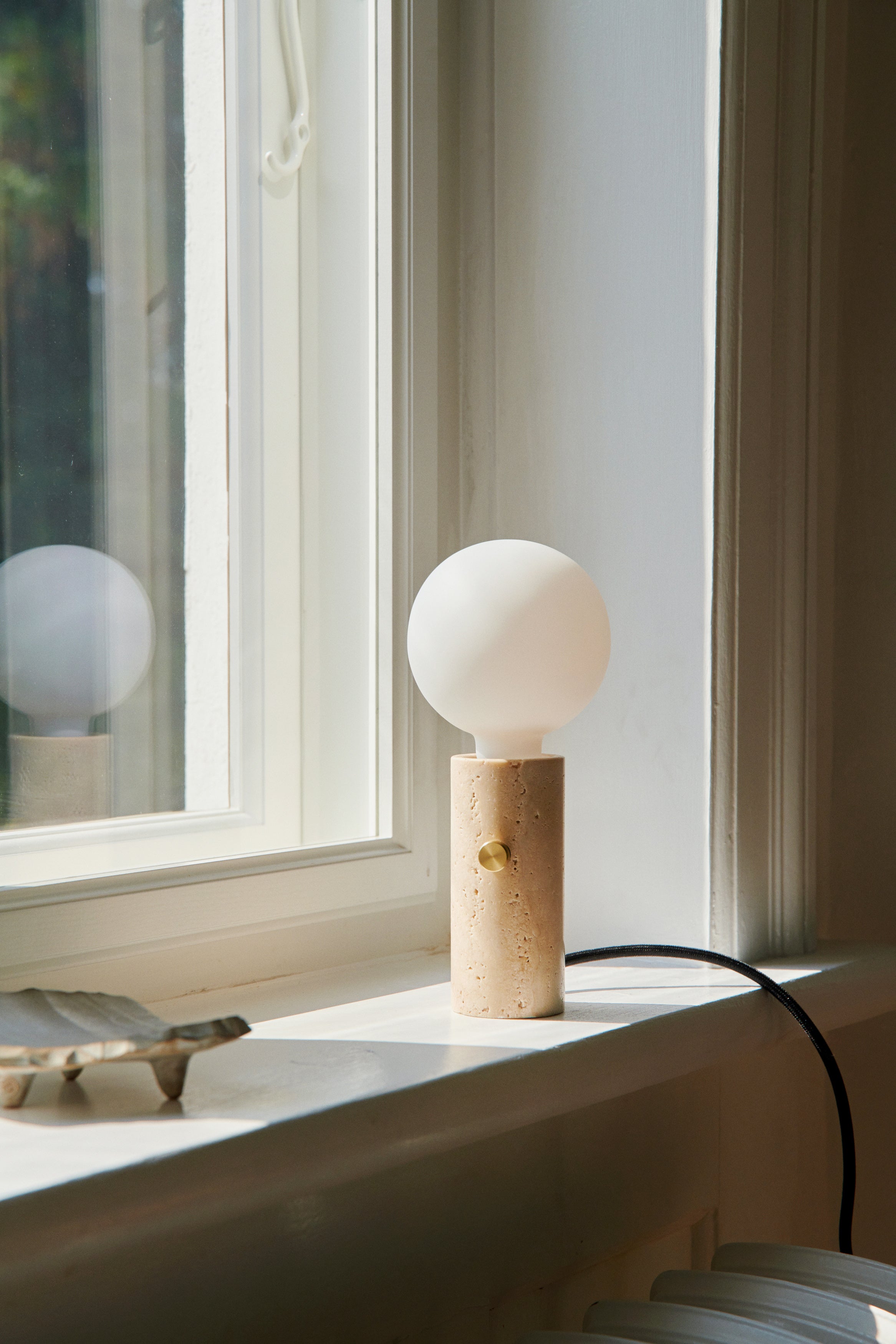 Core lampen i Creme Travertin brugt som bordlampe i vindueskammen