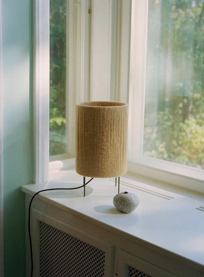 Den unikke og skandinaviske designet Ro Ø23 Bordlampe i Jute placeret i vindueskammen for dens behagelige belysning