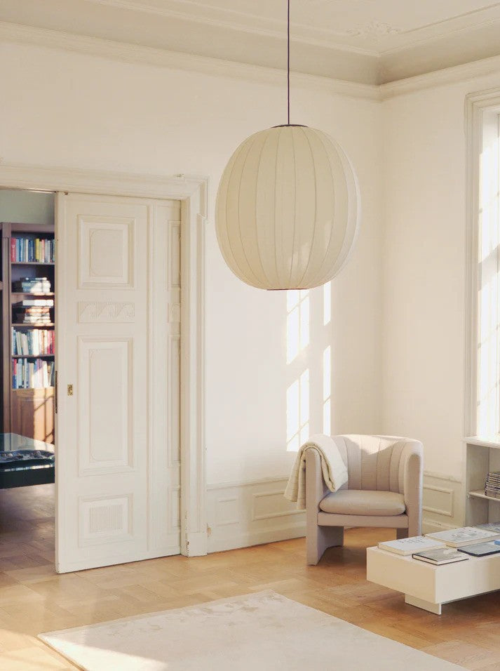 Den æstetiske Knit-Wit Ø65 High Oval Pendel hængt op i stuen for dens elegante design