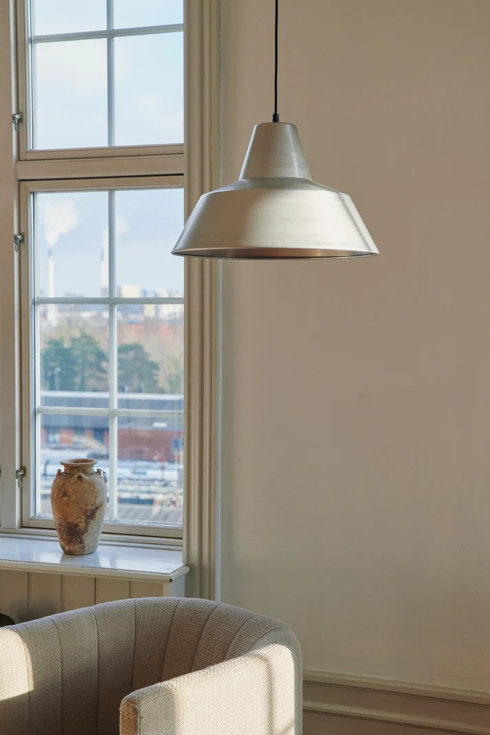 Den unikke og elegante designet Workshop Pendel W3 i Aluminium hængt op i stuen for dens behagelige og varme belysning i hele rummet