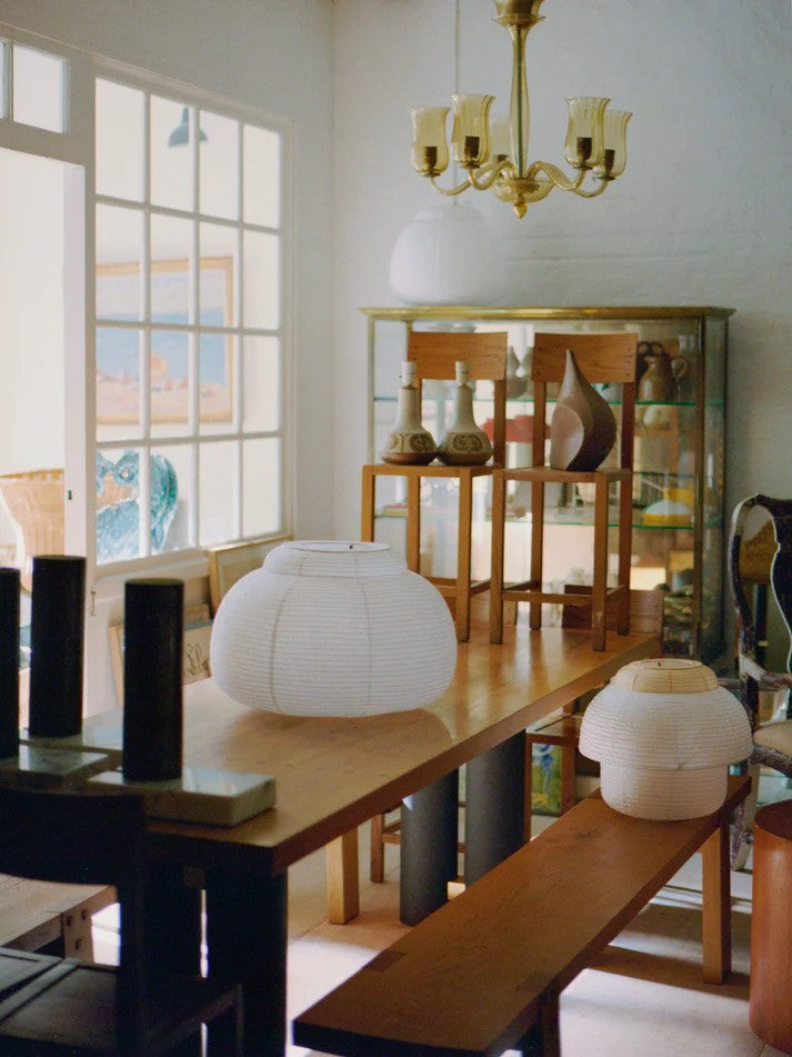 Den unikke designet Papier Double Ø40 Pendel i Gul placeret på en bænk