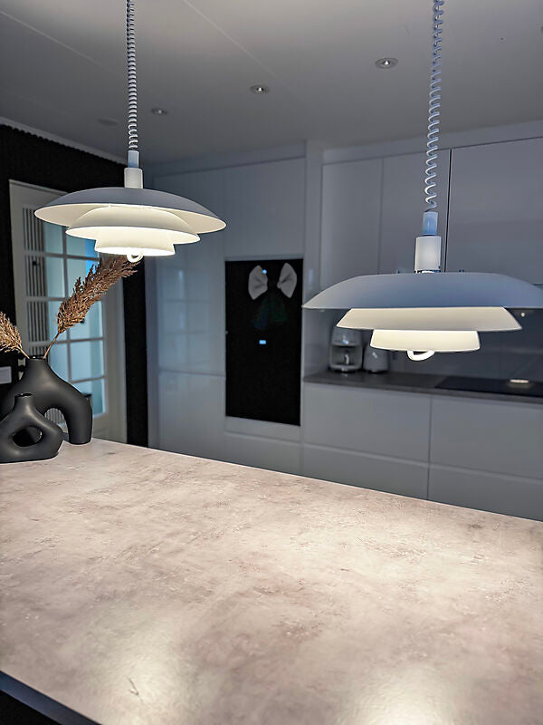 Den æstetiske Epsilon Ø45 Pendel med hejs i Hvid hængt op over køkkenøen for dens behagelige belysning