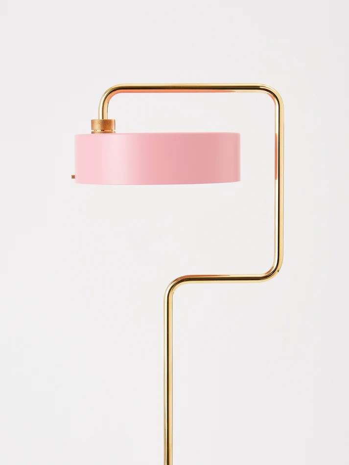 Den æstetiske Petite Machine Gulvlampe i Lys Pink placeret foran en væg for en flot kontrast