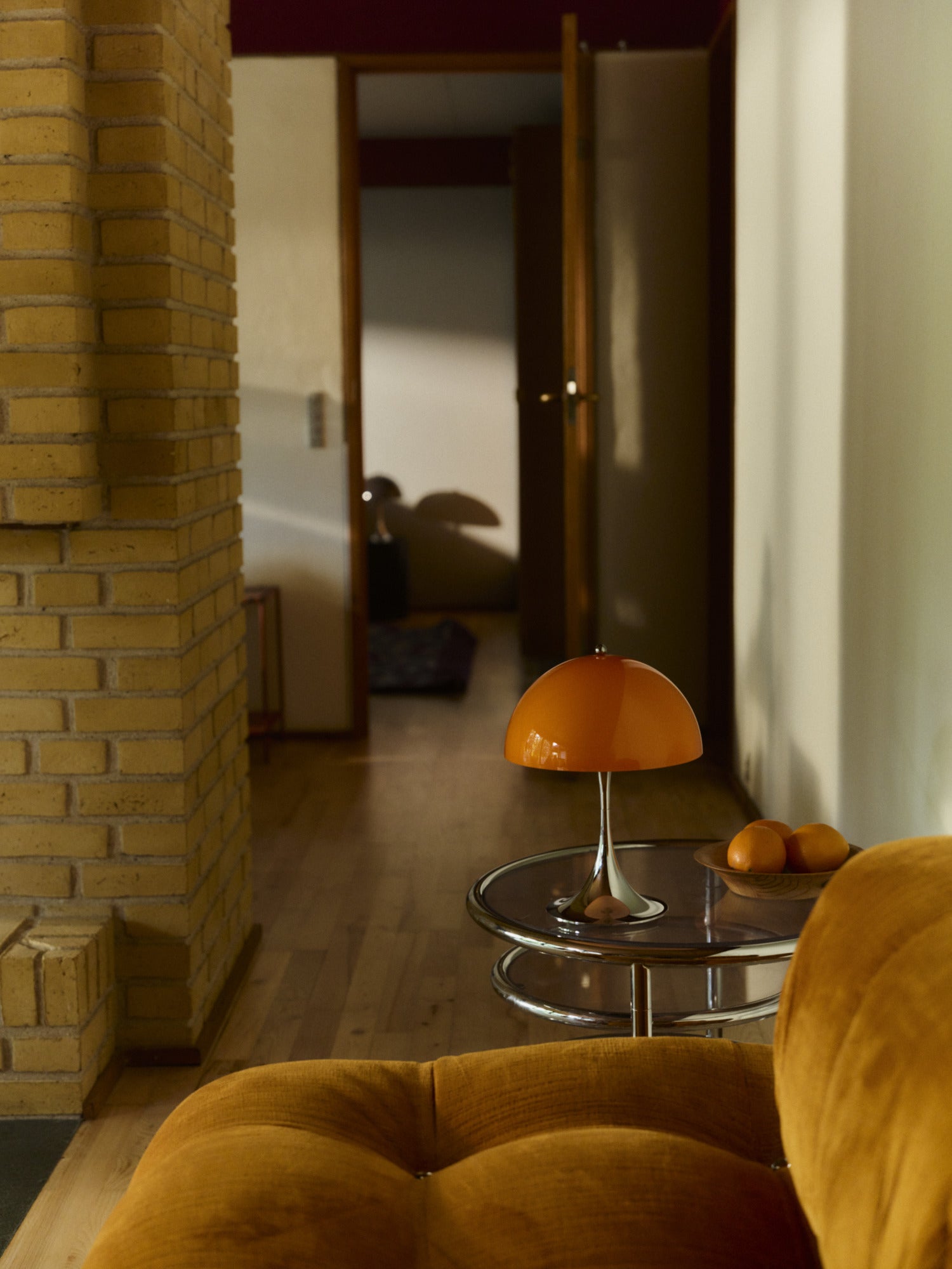 Panthella 250 Portable Lampe Original Opal Orange i gangen ved sofaen