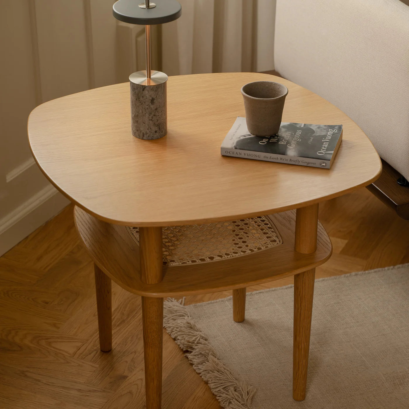 Den elegante designet Asteria Move Mini i Grey Marble Stål placeret på et bord i stuen for dens varme belysning