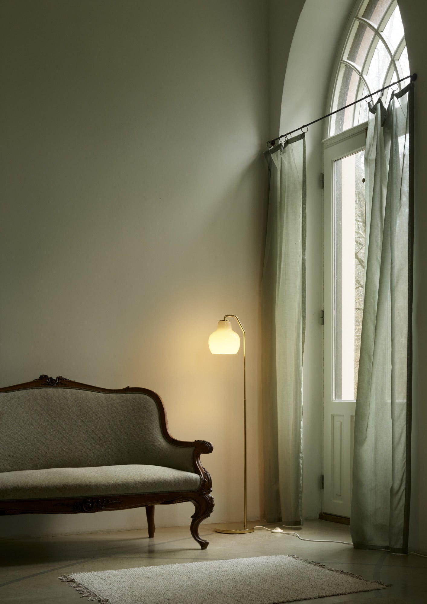 VL Ring Crown E27 gulvlampe messing/opal i stuen ved sofa