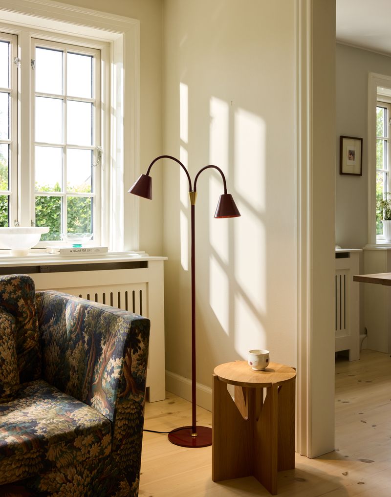 Hygge 2-arm Gulvlampe Merlot placeret i hjørnet af stuen for dens varme belysning og 2 individuelle afbrydere