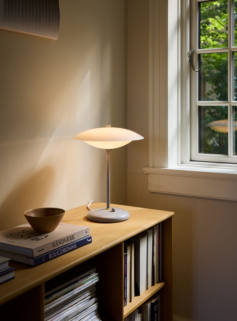 Baroni Bordlampe Ø30 Grå placeret på hylden i stuen for dens varme belysning