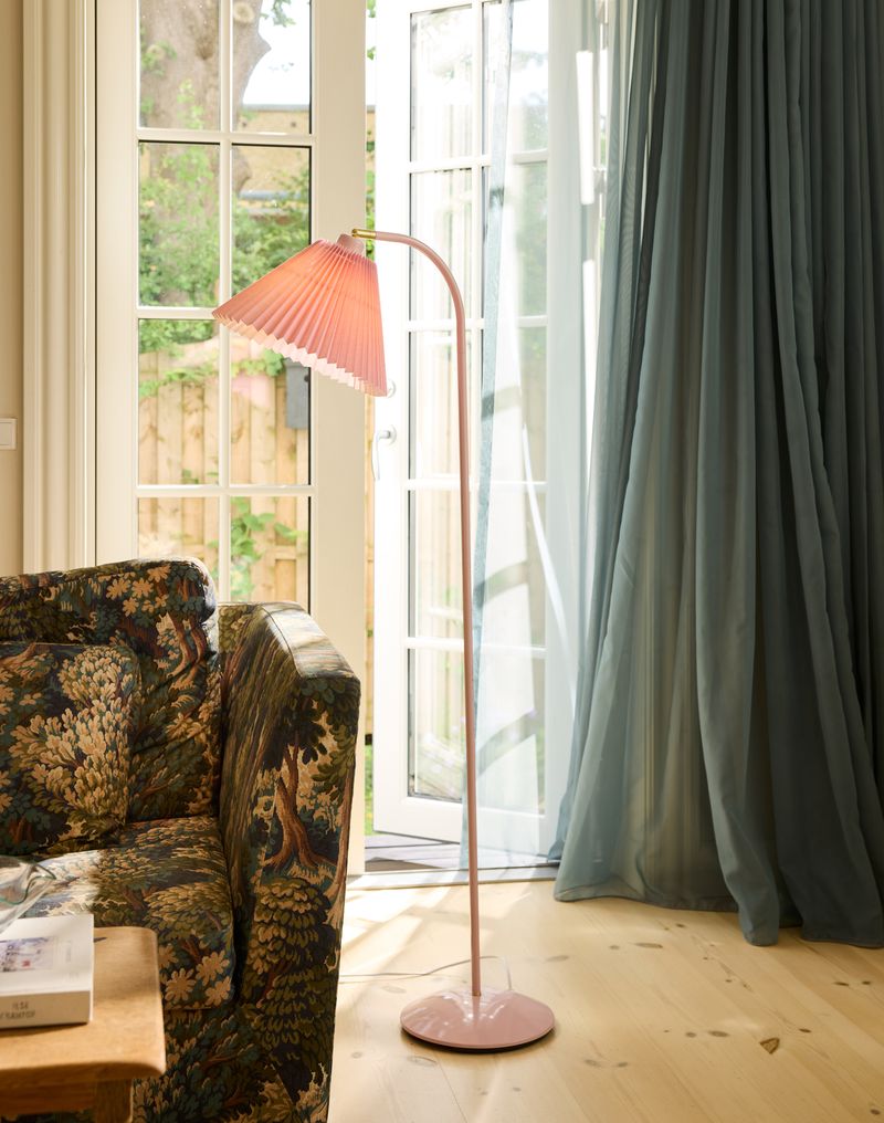 Medina Gulvlampe Rose placeret i stuen ved sofaen for dens behagelige belysning i hele rummet