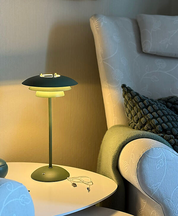Den unikke designet Epsilon Recharge Bordlampe i Grøn placeret i stuen for dens behagelige belysning