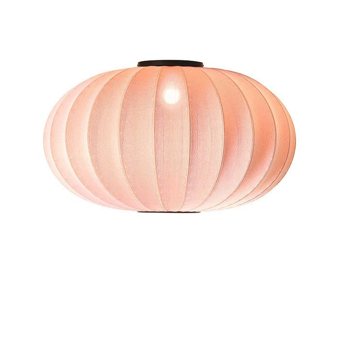 Zoomet helt ind på den æstetiske Knit-Wit Ø76 Oval Loftslampe i Coral med en E27 pære iført og tændt for den behagelige belysning i hele rummet