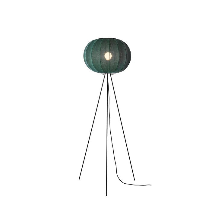 Knit-Wit Ø45 Round Gulvlampe High i Tweed Green sat op foran en væg med en E27 pære iført og tændt