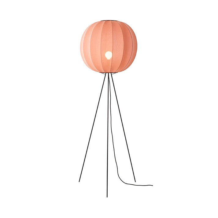 Den æstetiske Knit-Wit Ø60 Round Gulvlampe High i Coral placeret foran en hvid væg med en E27 pære iført