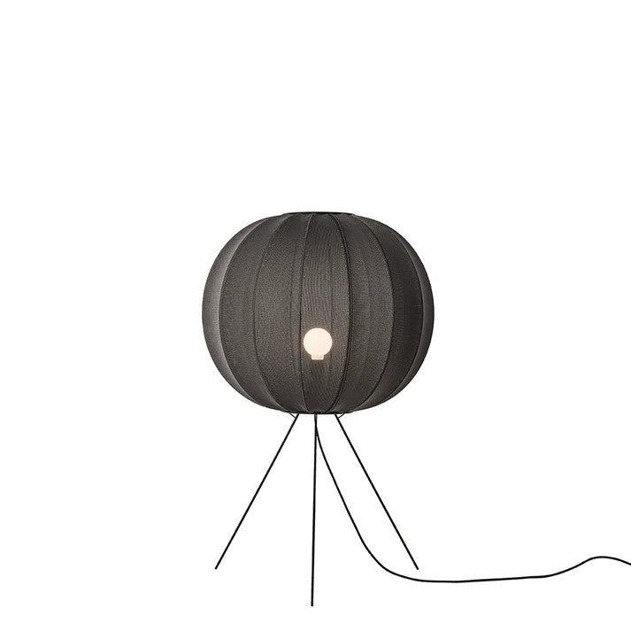 Zoomet ind på den æstetiske Knit-Wit Ø60 Round Gulvlampe Medium Black placeret foran en hvid væg for den flotte kontrast med en E27 pære iført