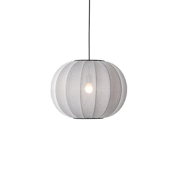 Den æstetiske Knit-Wit Ø45 Round Pendel i Silver hængt op foran en hvid væg for en flot kontrast med en tændt E27 pære