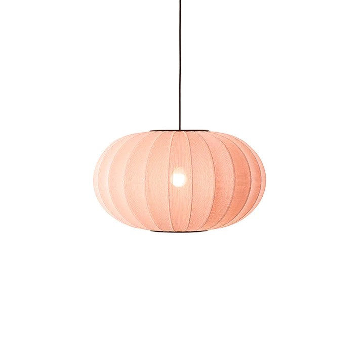 Den æstetiske Knit-Wit Ø57 Oval Pendel i Coral hængt op med en tændt E27 pære iført