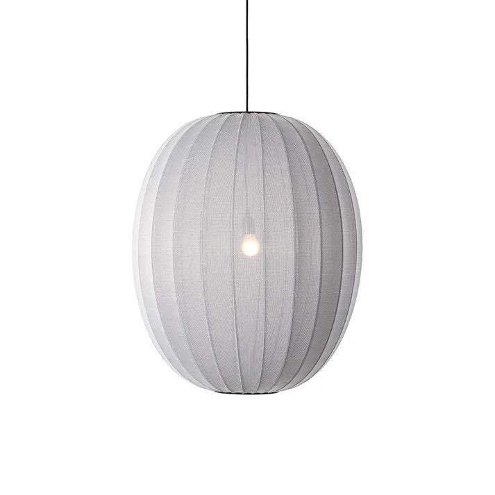 Den æstetiske Knit-Wit Ø65 High Oval Pendel i Silver hængt op foran en hvid væg for en flot kontrast med en E27 pære iført