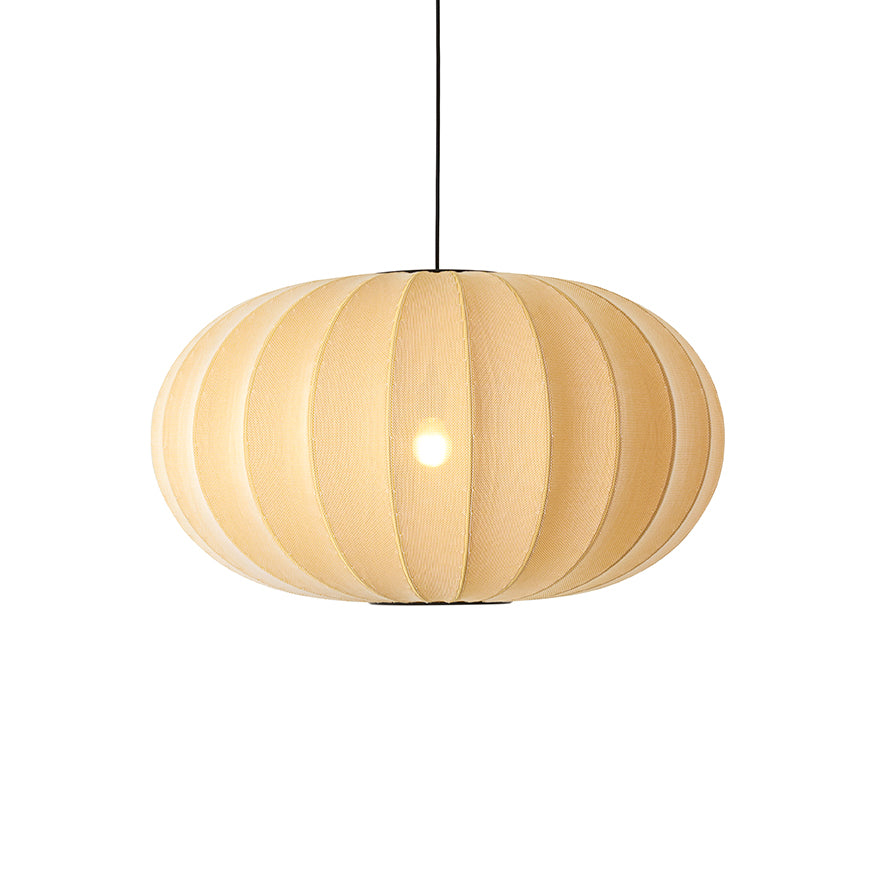 Den elegante Knit-Wit Ø76 Oval Pendel i Sunrise hængt op med en E27 pære iført og tændt for den behagelige belysning i hele rummet