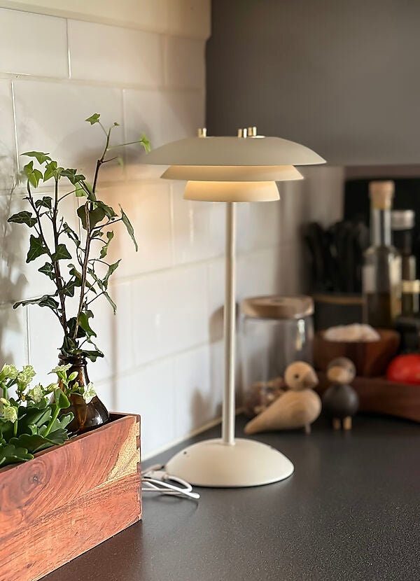 Zoomet ind på den elegante Epsilon Recharge Bordlampe i Beige placeret på køkkenbordet