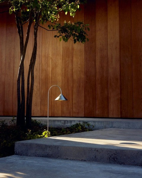 Den æstetiske Grasp Garden Spear i Brushed Stainless Steel placeret udenfor ved hoveddøren for dens hyggelige belysning