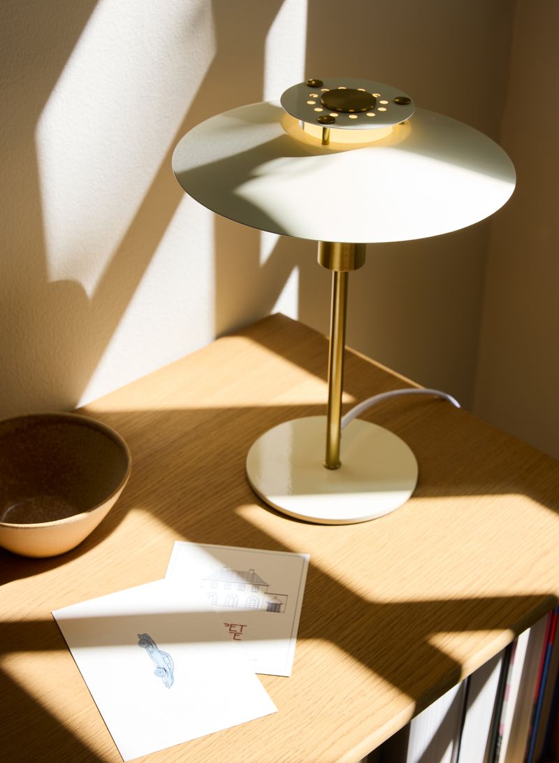 Rivoli Bordlampe Ø24 Cream placeret i stuen for dens behagelige belysning
