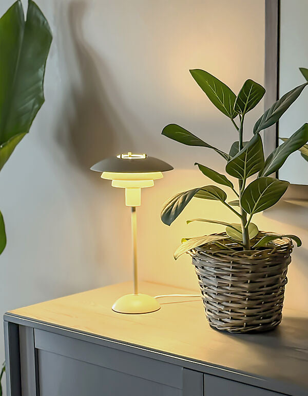 Den elegante designet Epsilon Bordlampe i Beige placeret i stuen for dens behagelige belysning