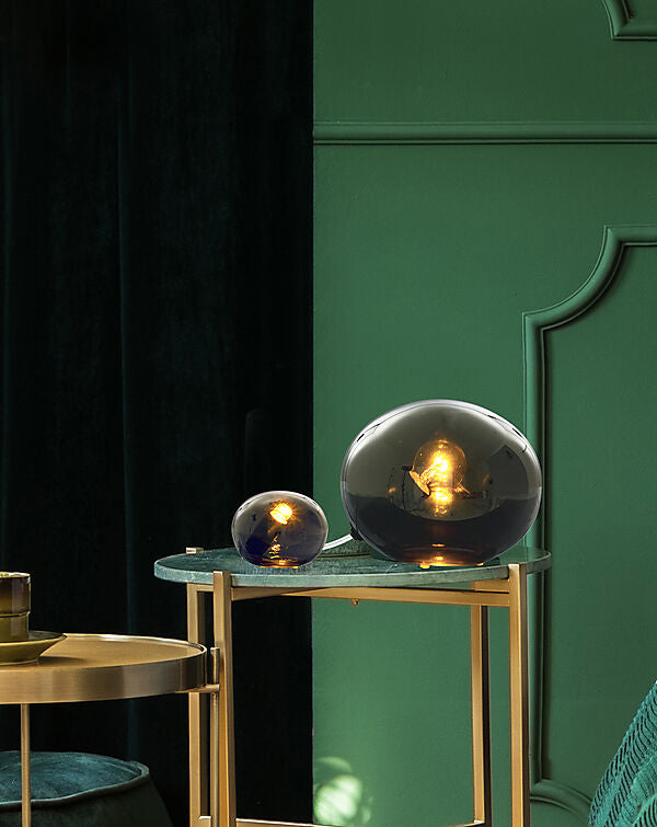 Den æstetiske Globus Ø13 Bordlampe i Røgfarvet placeret i stuen på et bord for dens behagelige belysning