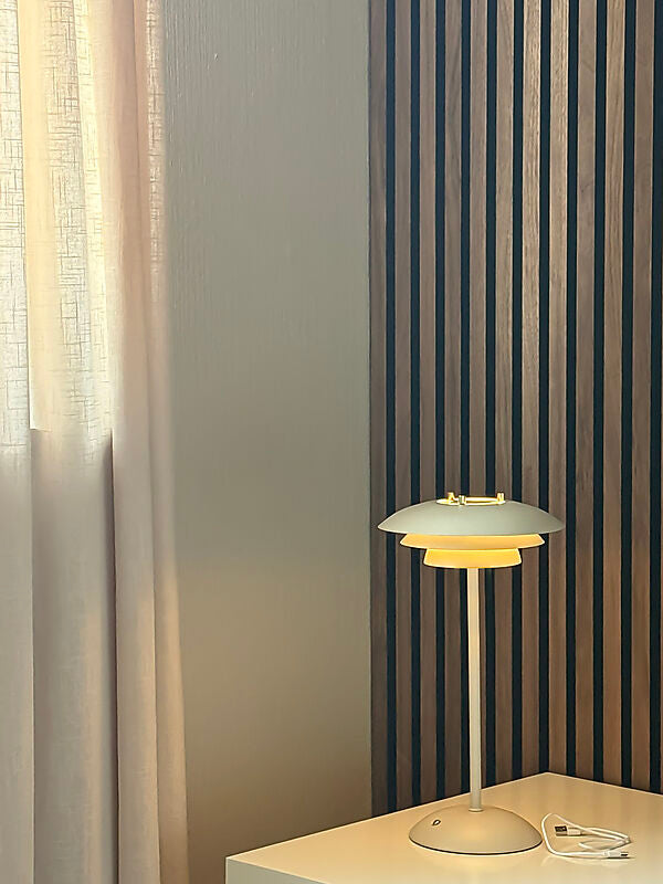 Den æstetiske Epsilon Recharge Bordlampe i Beige placeret i stuen for dens behagelige belysning