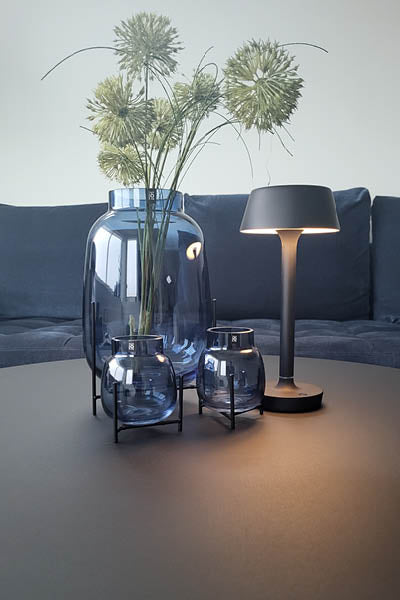 Antidark portable lampe på et bord sammen med glasvaser
