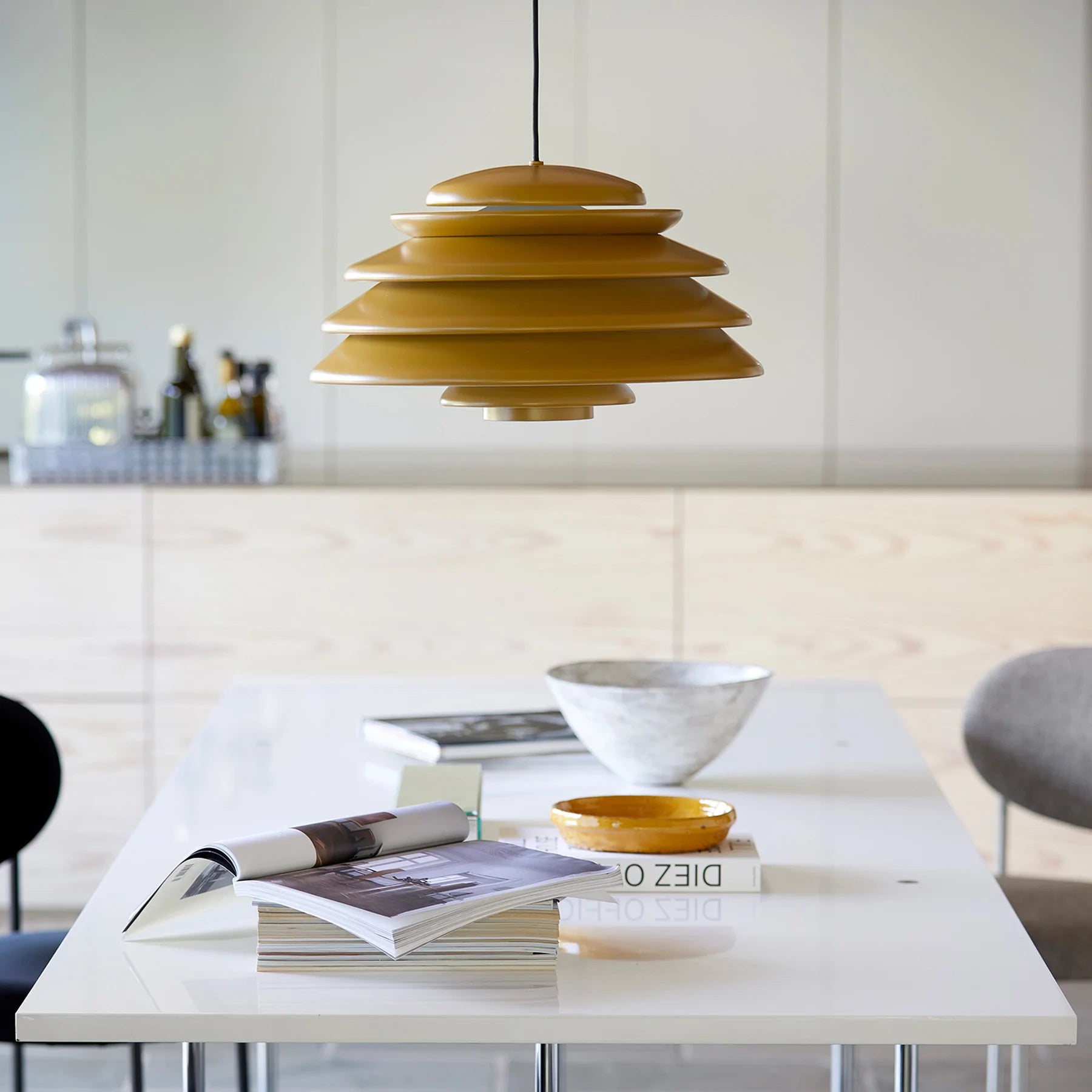 Gul loftlampe monteret over et spisebord