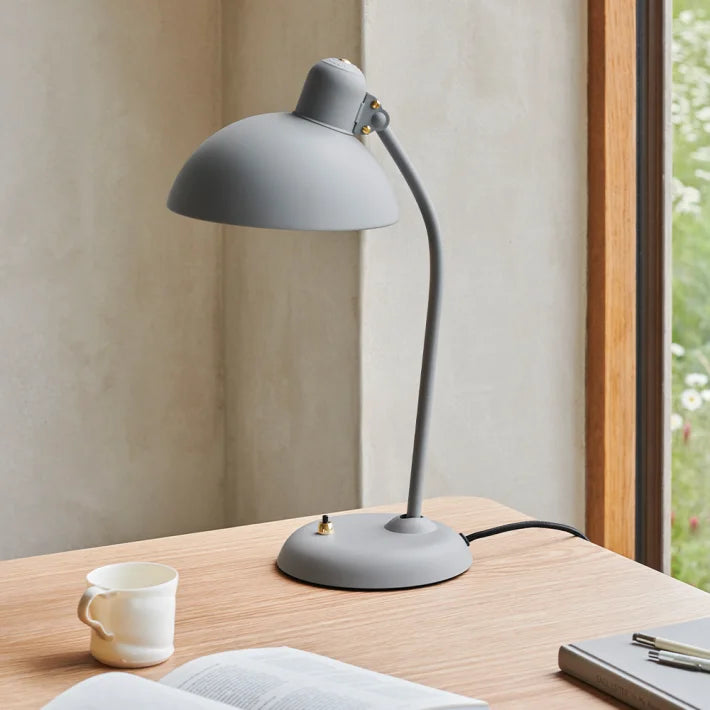 Smuk grå Fritz Hansen bordlampe på skrivebord med en kop kaffe